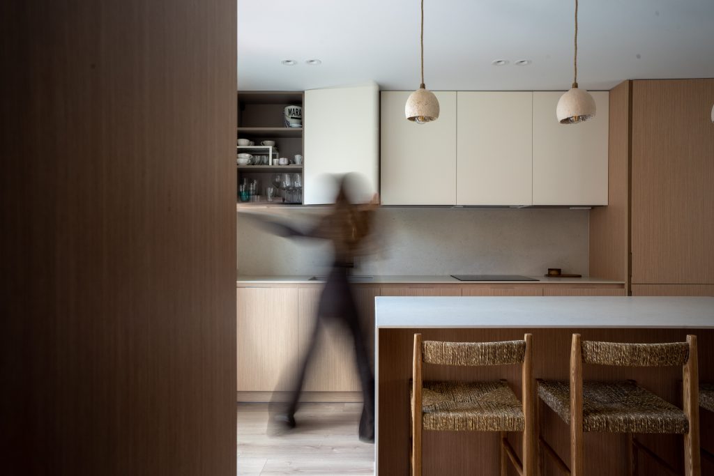 Salón comedor con sofá blanco y mesa de madera iluminado por luz natural
